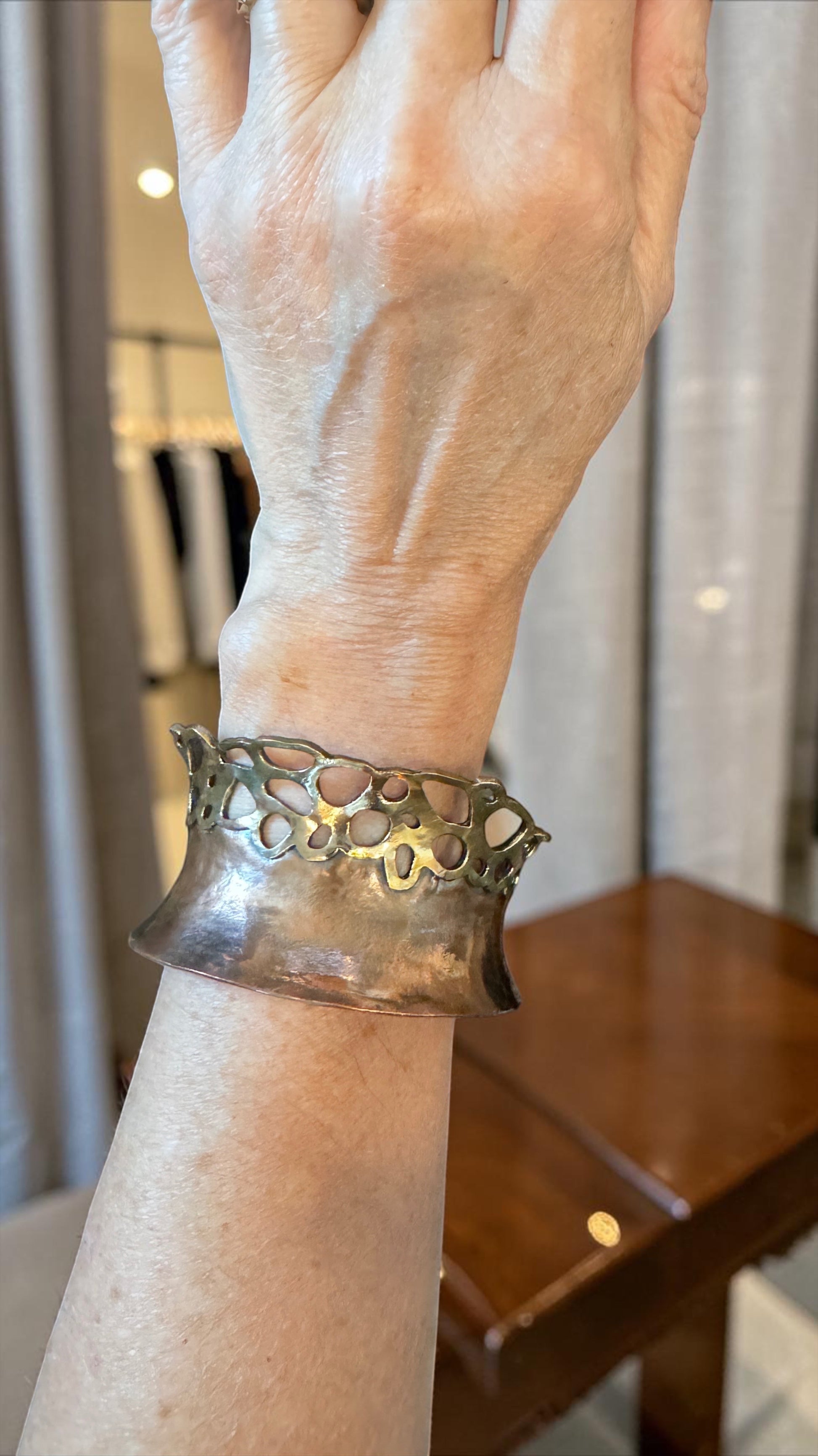 Bedrock Rose lacy pierced copper and brass cuff bracelet worn on a wrist