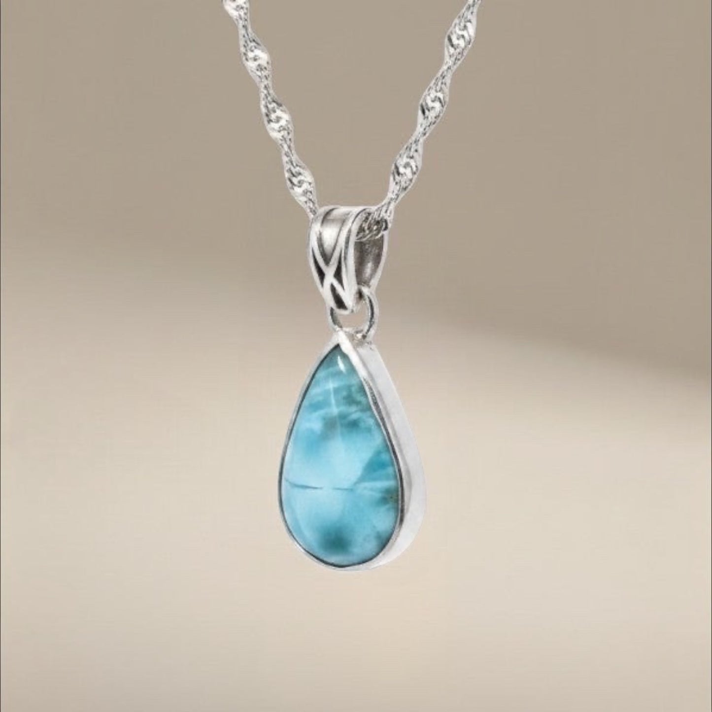 Bedrock Rose handcrafted sterling silver teardrop pendant featuring a blue and white swirling larimar gemstone.