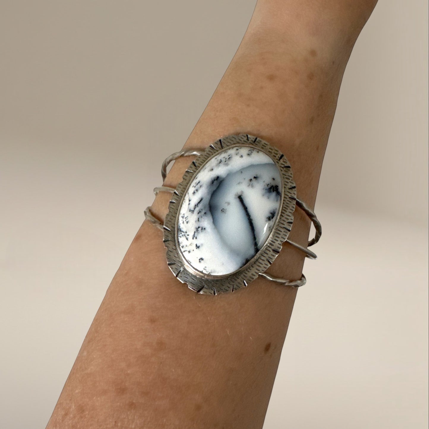 Bedrock Rose statement cuff featuring a large oval Merlinite stone set in textured sterling silver on a wrist