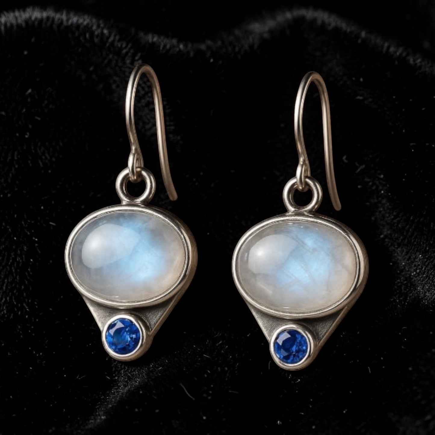 Bedrock Rose artisan dangle earrings featuring oval moonstones and blue sapphires set in hand-milled sterling silver.