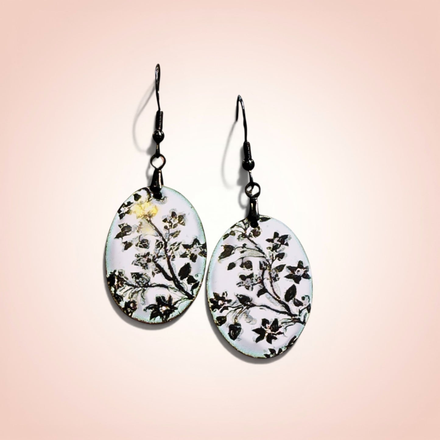 Bedrock Rose hand-enameled oval copper earrings with black floral design on white enamel.