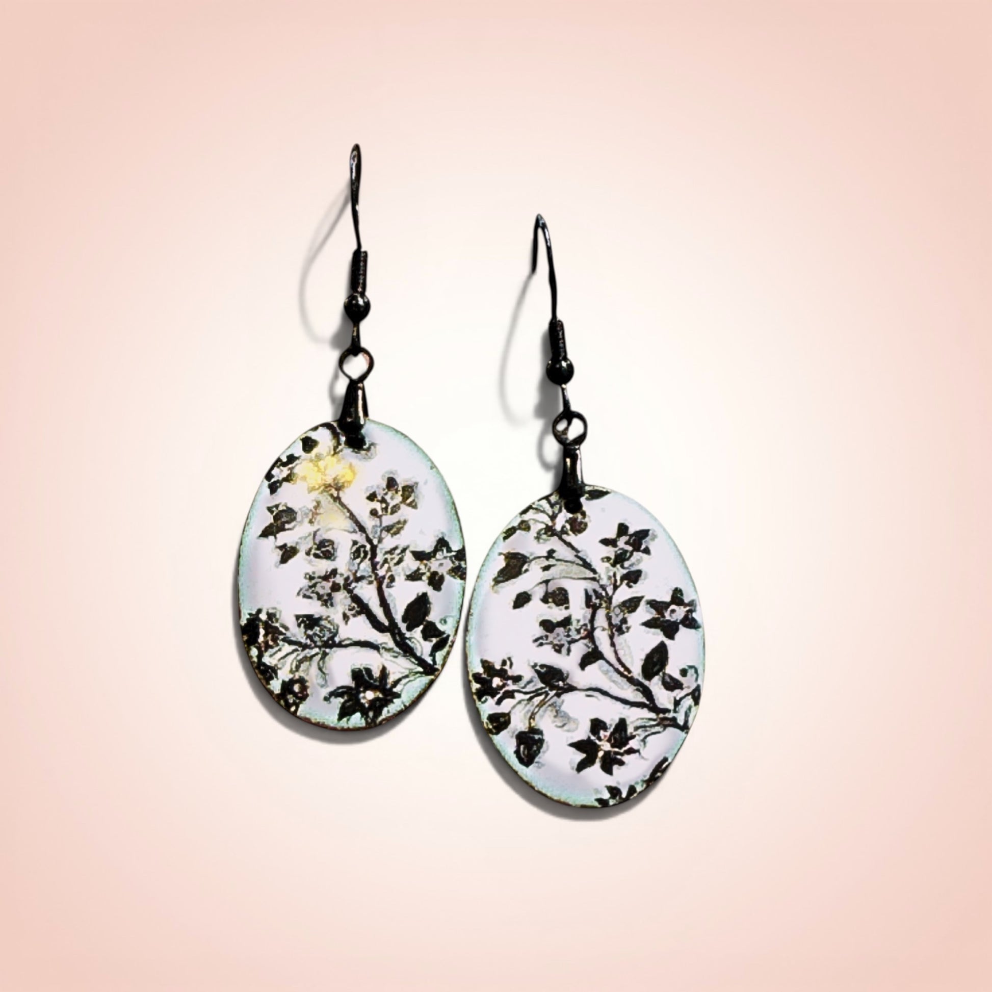 Bedrock Rose hand-enameled oval copper earrings with black floral design on white enamel.