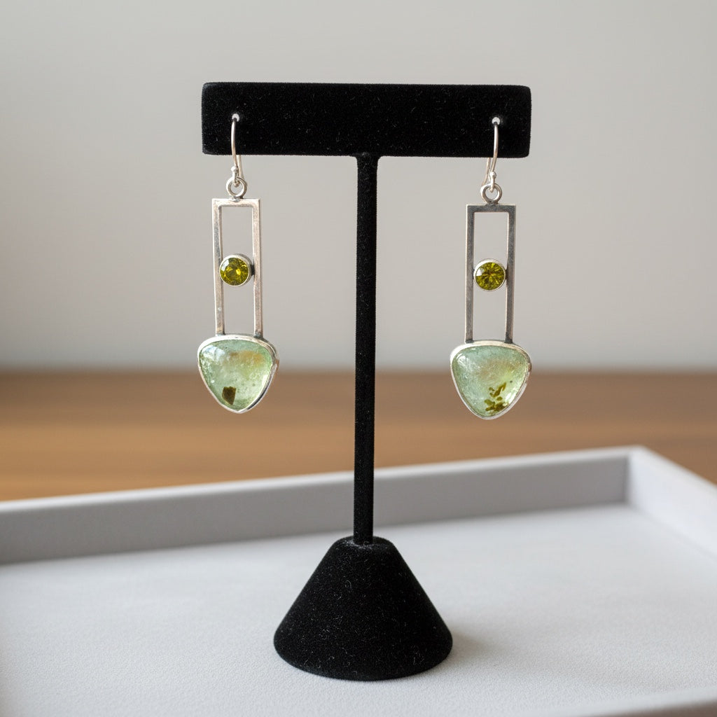 Bedrock Rose sterling silver dangle earrings with geometric design, featuring translucent pale green prehnite and olive-green peridot gemstones.