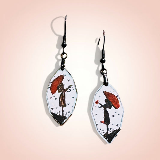 Bedrock Rose hand-painted enamel dangle earrings featuring a girl with a red umbrella on a white background.