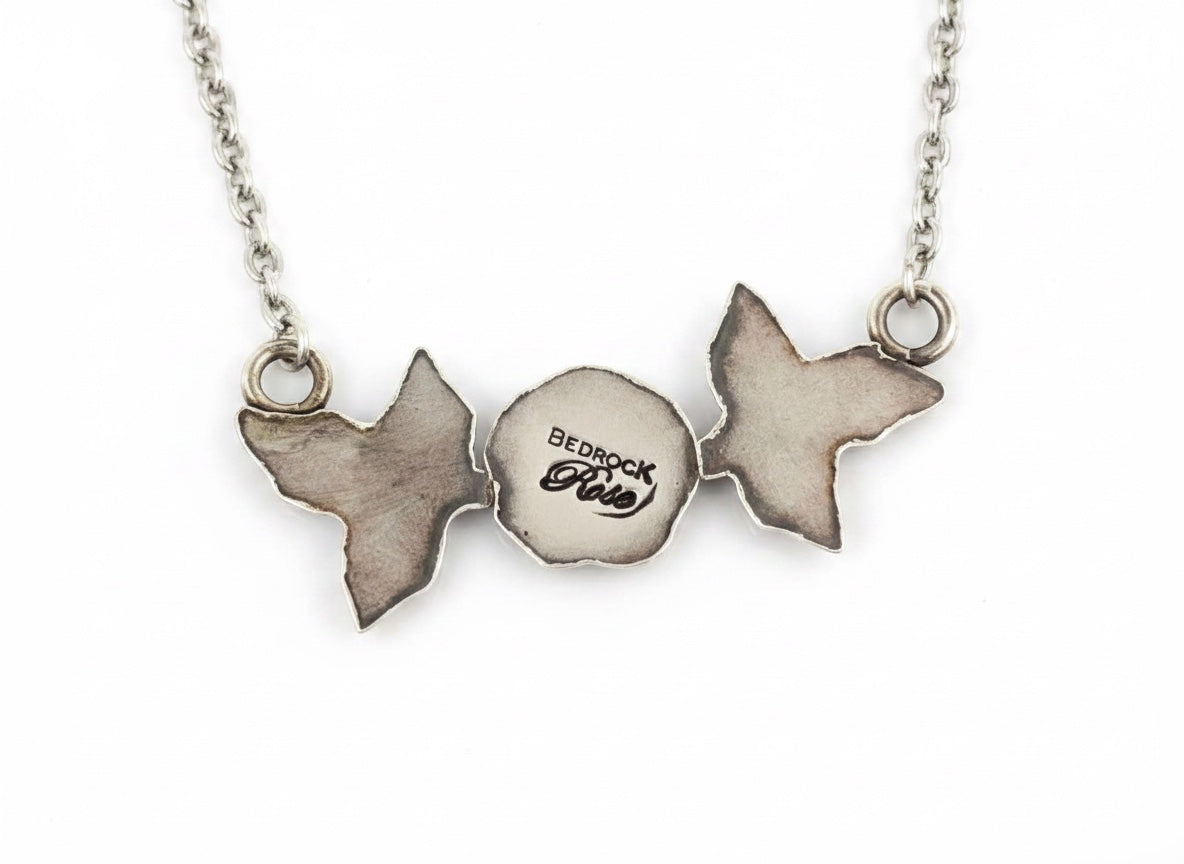 Bedrock Rose sterling silver necklace with rosebud and leaf pendant. Delicate nature-inspired design.