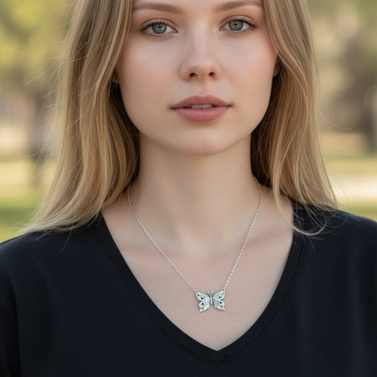 Bedrock Rose fine silver butterfly pendant on a delicate stainless steel cable chain worn by a blonde woman.