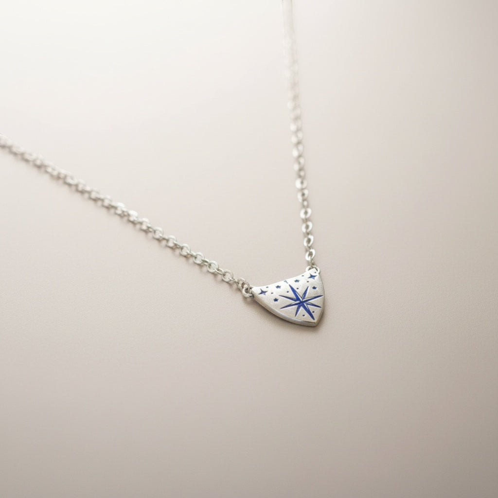 Bedrock Rose silver compass rose medallion pendant necklace with blue accents on a delicate sterling silver chain.