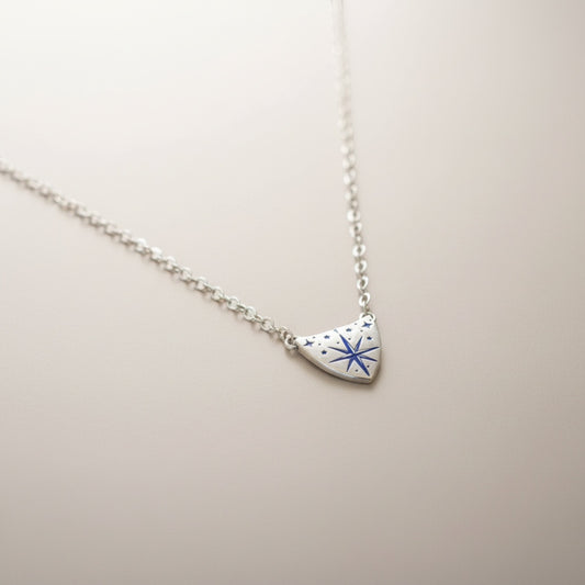 Bedrock Rose silver compass rose medallion pendant necklace with blue accents on a delicate sterling silver chain.