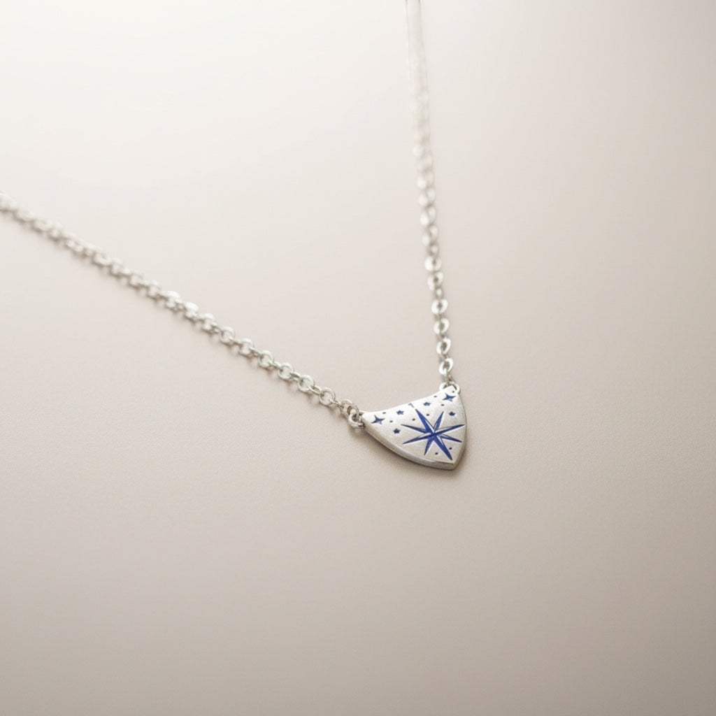 Bedrock Rose silver compass rose medallion pendant necklace with blue accents on a delicate sterling silver chain.