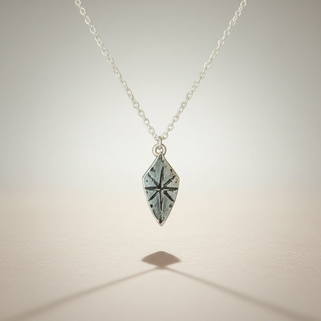 Bedrock Rose silver compass rose shield pendant necklace on a delicate sterling silver cable chain.