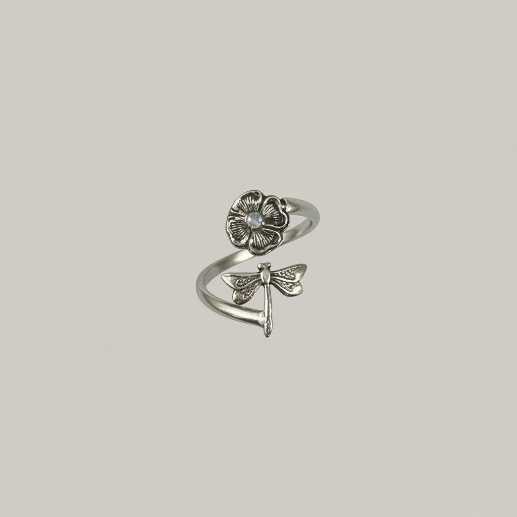 Bedrock Rose sterling silver wraparound ring with a dragonfly on a flower, featuring intricate detailing and a small moonstone accent.