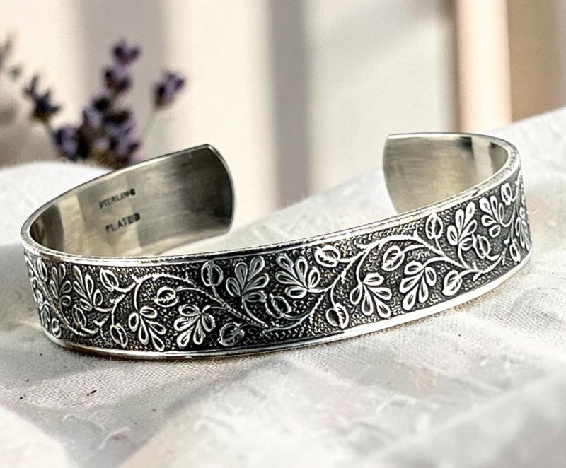 Bedrock Rose sterling silver-plated cuff bracelet featuring an intricate vintage floral vine pattern with patination.