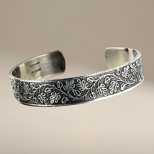 Bedrock Rose sterling silver-plated cuff bracelet featuring an intricate vintage floral vine pattern with patination.