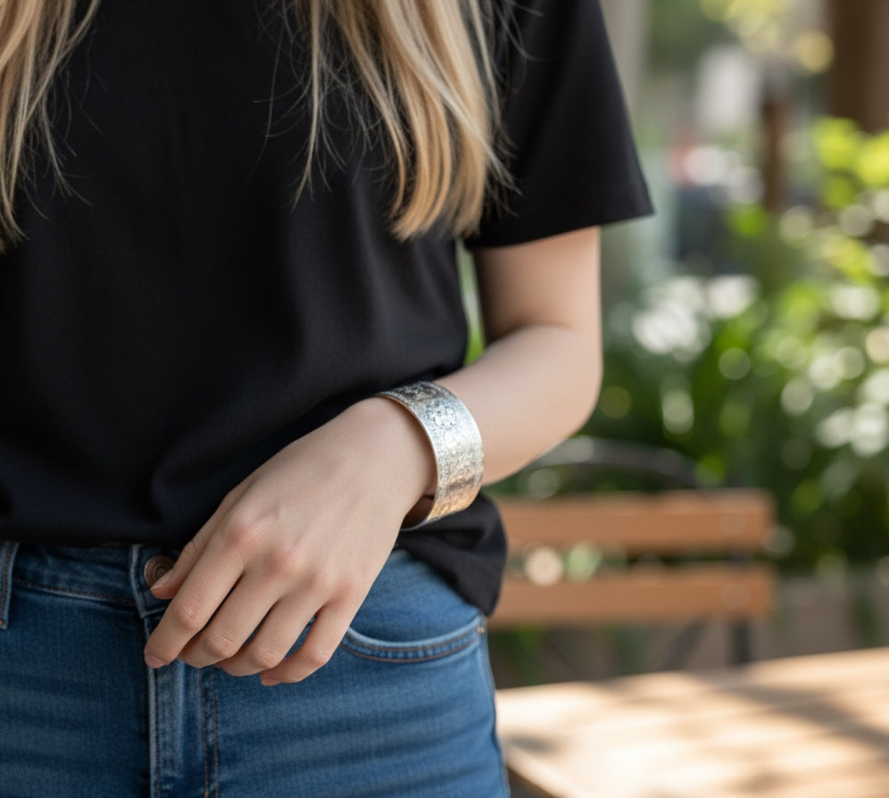 Bedrock Rose sterling silver-plated cuff bracelet featuring an intricate floral flourish design on a woman's wrist.