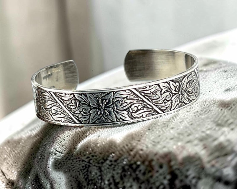 Bedrock Rose sterling silver-plated cuff bracelet featuring an intricate floral monument flower design with patination.