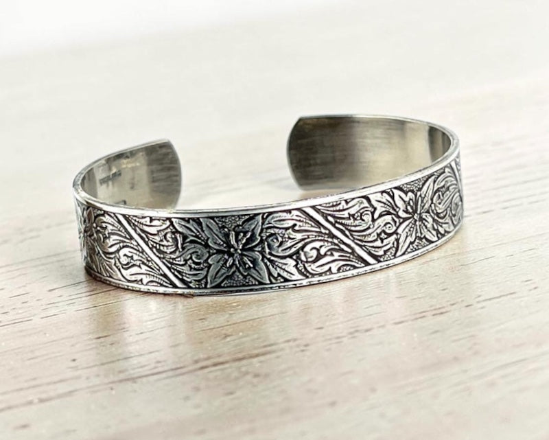 Bedrock Rose sterling silver-plated cuff bracelet featuring an intricate floral monument flower design with patination.