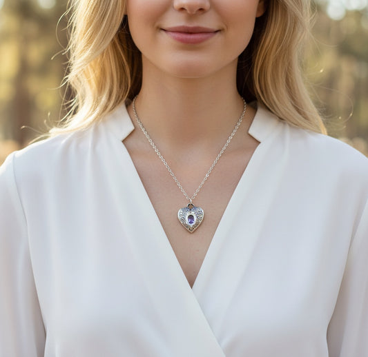 Bedrock Rose fine silver heart pendant with an amethyst CZ stone on a stainless steel chain worn by a woman.