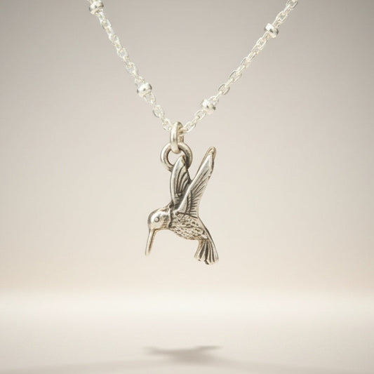 Bedrock Rose sterling silver hummingbird necklace with a delicate satellite chain. Whimsical bird pendant.