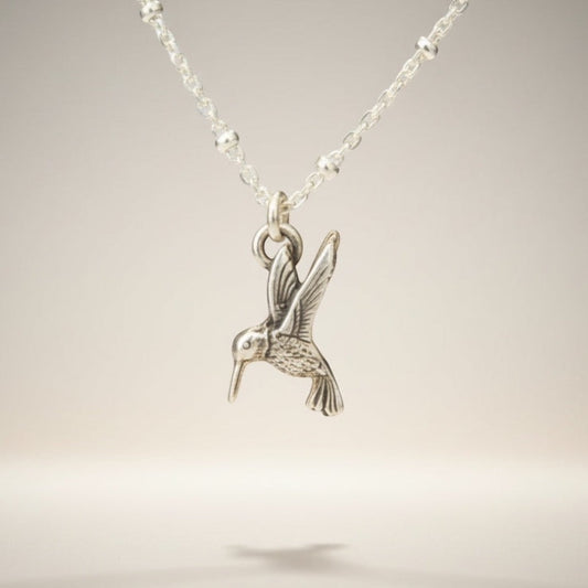 Bedrock Rose sterling silver hummingbird necklace with a delicate satellite chain. Whimsical bird pendant.