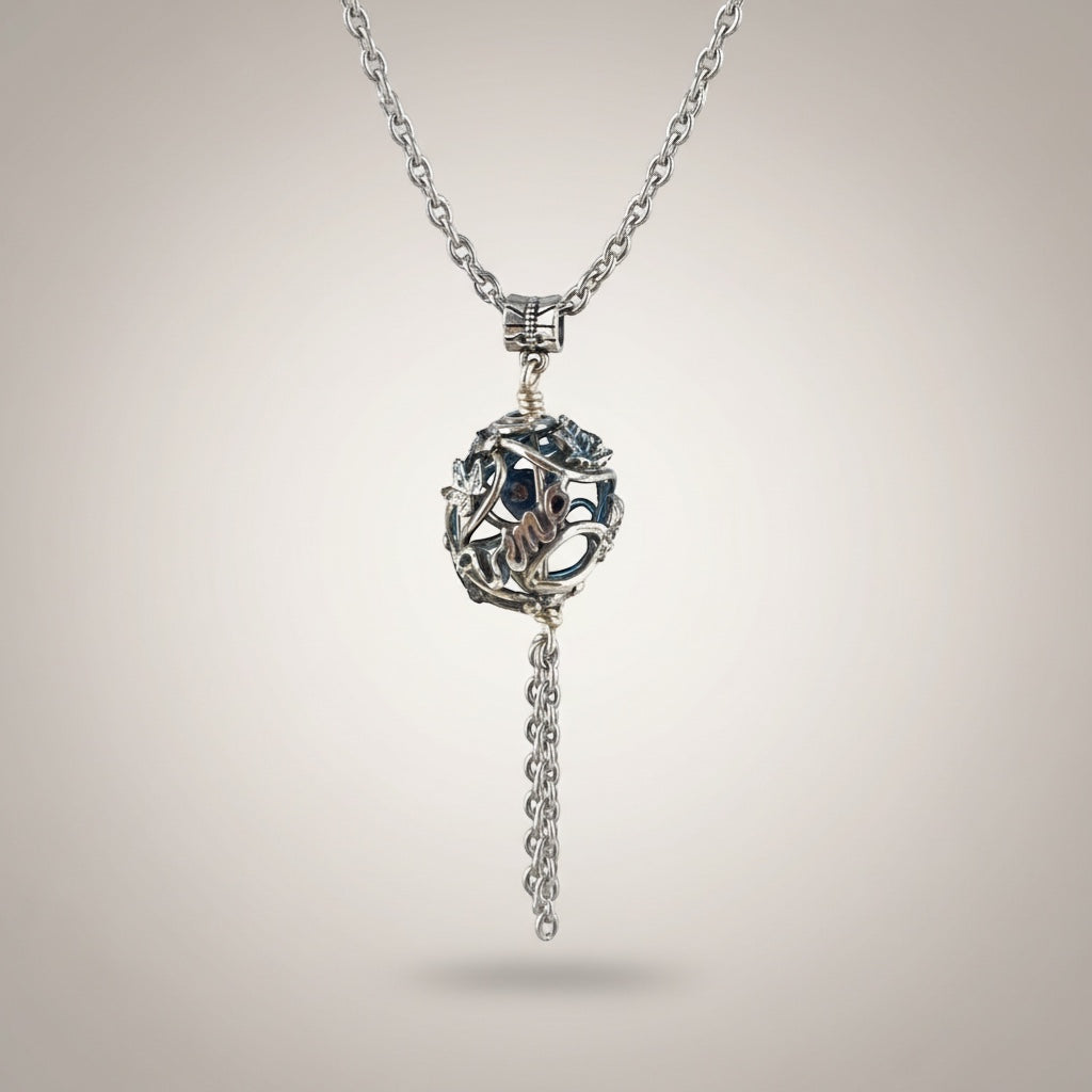 Bedrock Rose silver vine pendant necklace with grape clusters and leaves, featuring a hollow orb and chain tassel.