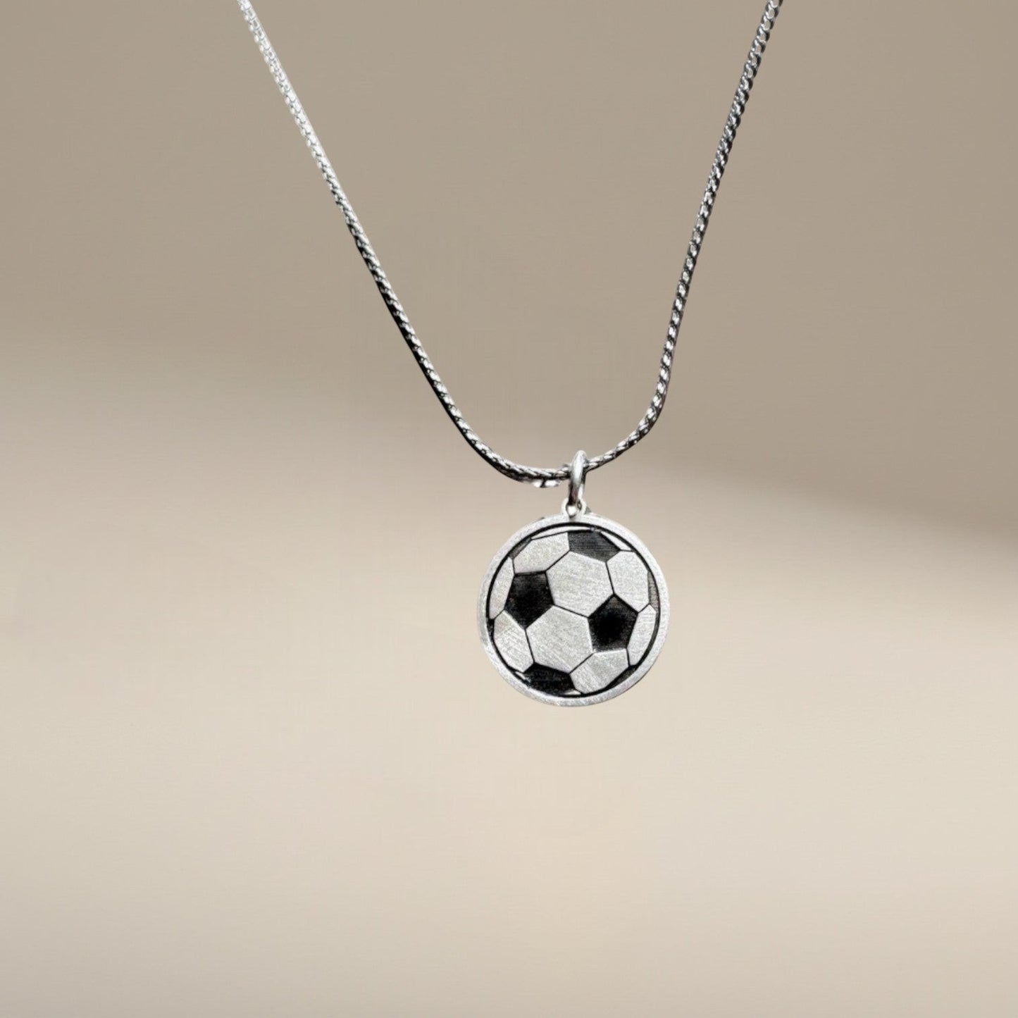 Bedrock Rose sterling silver soccer ball pendant necklace with laser-engraved panel details on a stainless steel chain.