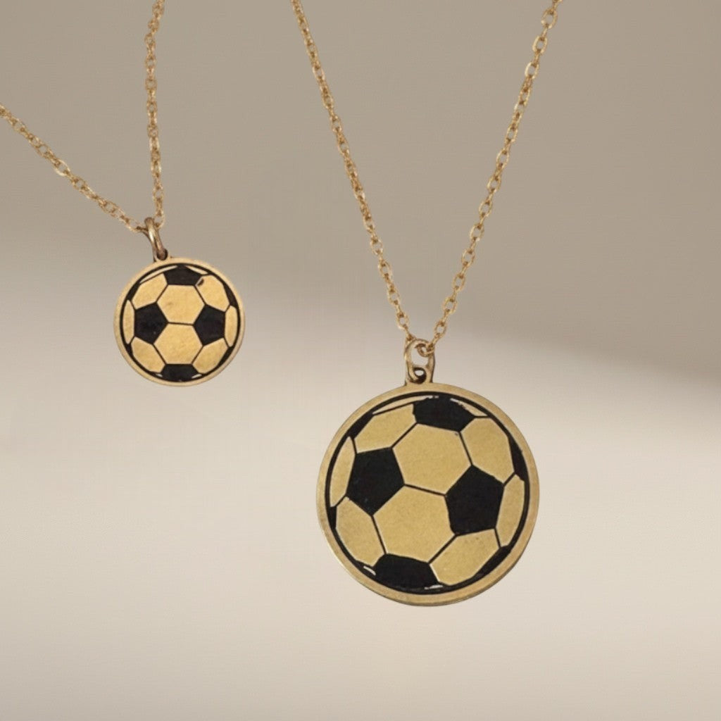 Bedrock Rose laser-engraved brass soccer ball pendant necklaces in two sizes on stainless steel chains.