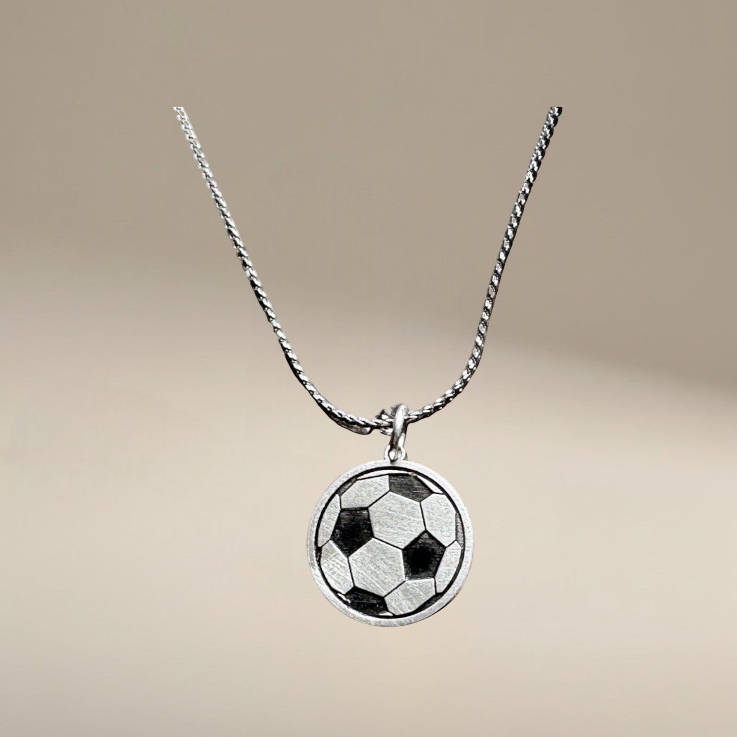 Bedrock Rose sterling silver soccer ball pendant necklace with laser-engraved details on a stainless steel chain.