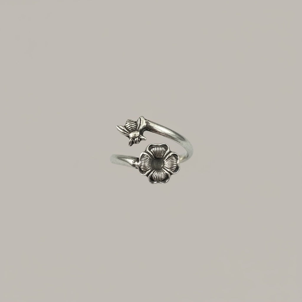 Bedrock Rose sterling silver wrap ring featuring a detailed honeybee and blossom with an oxidized patina finish.