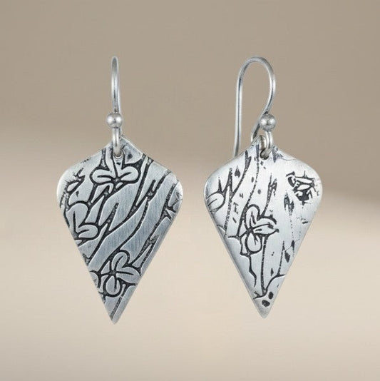 Bedrock Rose sterling silver shield-shaped dangle earrings with oxidized botanical texture and floral details.