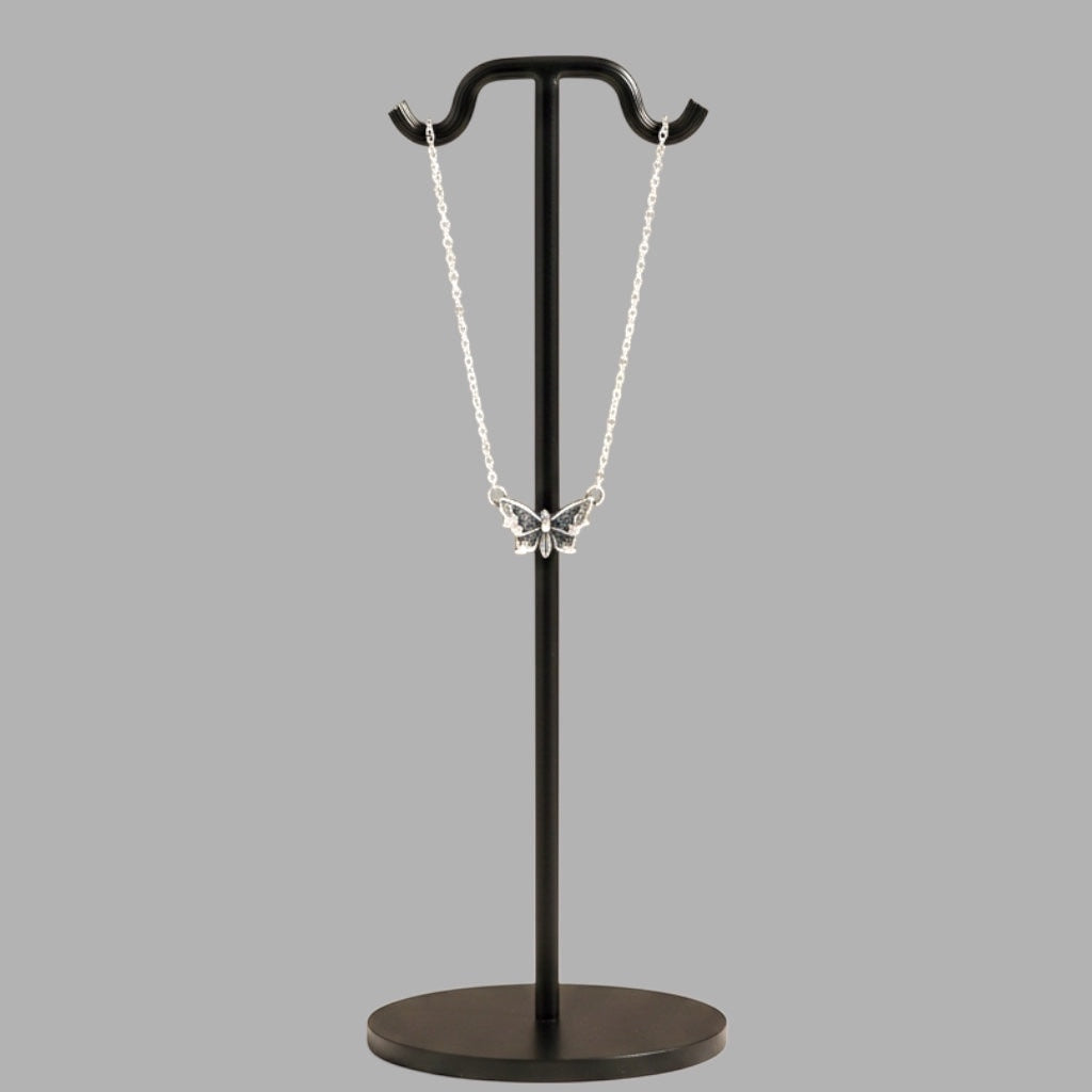 Bedrock Rose sterling silver butterfly pendant necklace with intricate wing details on a black display stand.