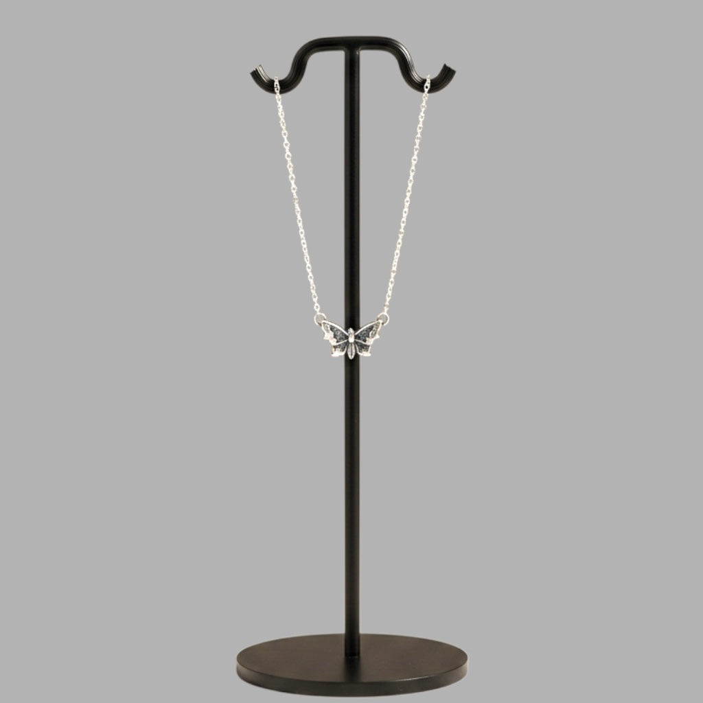 Bedrock Rose sterling silver butterfly pendant necklace with intricate wing details on a black display stand.