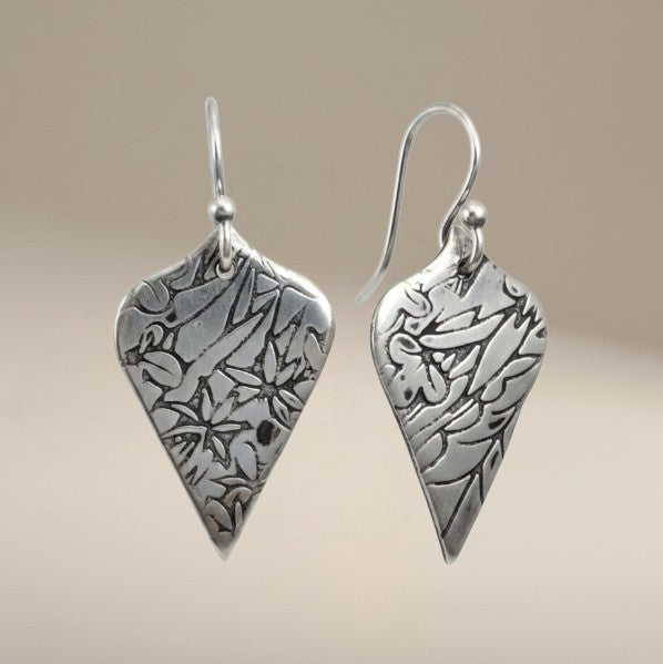 Bedrock Rose sterling silver shield dangle earrings with oxidized floral vine texture and botanical illustration style.