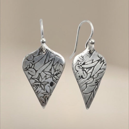 Bedrock Rose sterling silver shield dangle earrings with oxidized floral vine texture and botanical illustration style.