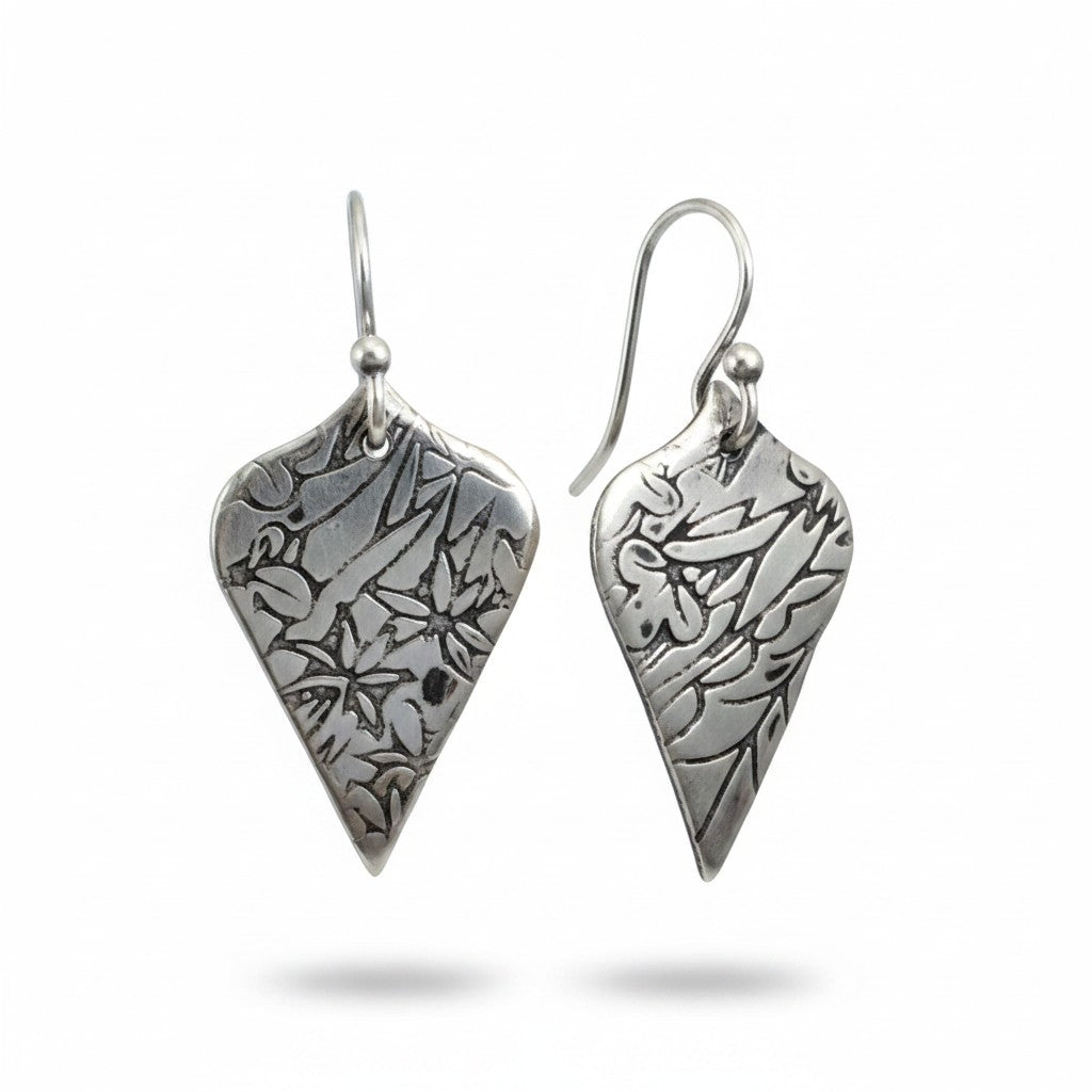 Bedrock Rose sterling silver shield dangle earrings with oxidized floral vine texture and botanical illustration style.