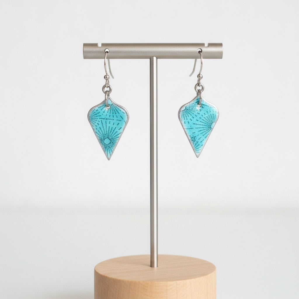 Bedrock Rose teal sunburst enamel dangle earrings featuring roll-printed fine silver and translucent glass.