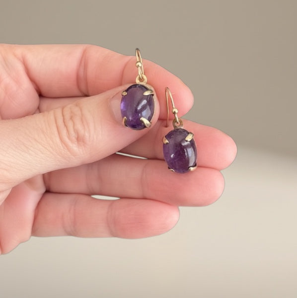 Bedrock Rose oval amethyst prong set dangle earrings with gold hooks.