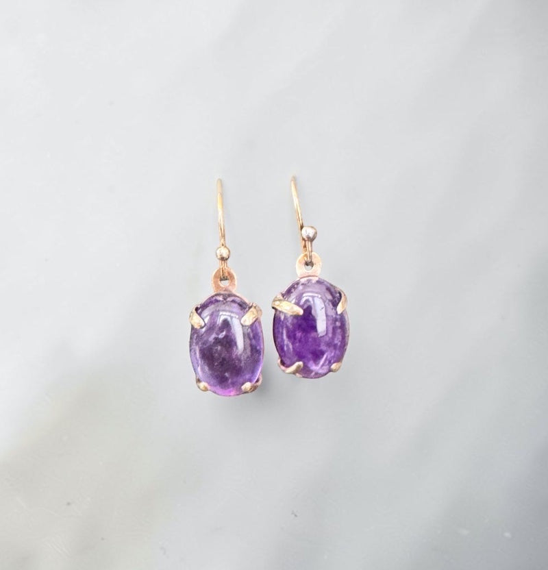 Bedrock Rose oval amethyst prong set dangle earrings with gold hooks.