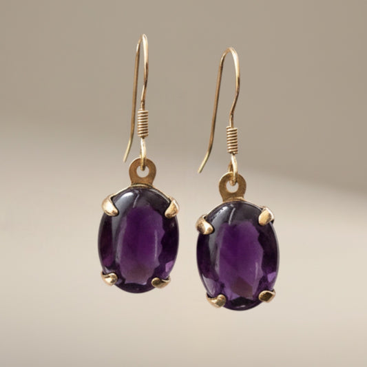 Bedrock Rose oval amethyst prong set dangle earrings with gold-tone hooks.