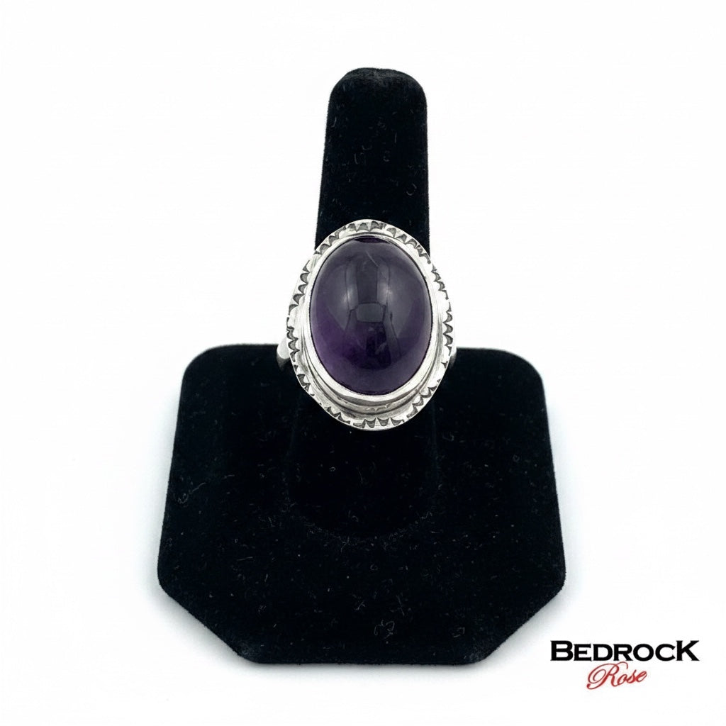Bedrock Rose oval amethyst statement ring in sterling silver with a bezel setting and decorative band. Size 8.