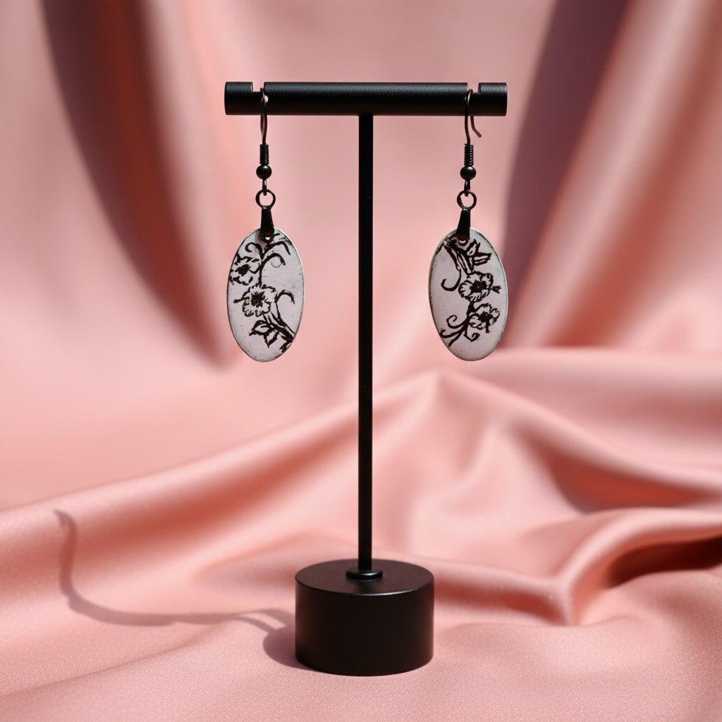 Bedrock Rose black and white oval enamel dangle earrings with floral design.