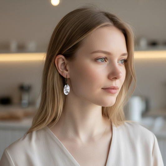 Bedrock Rose black and white oval enamel dangle earrings with floral design.