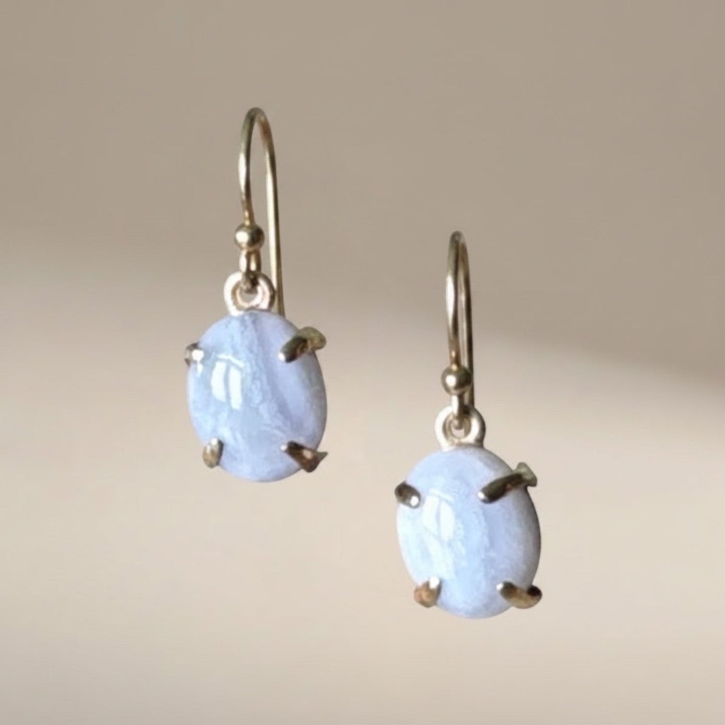 Bedrock Rose blue lace agate oval prong set dangle earrings with gold hooks.