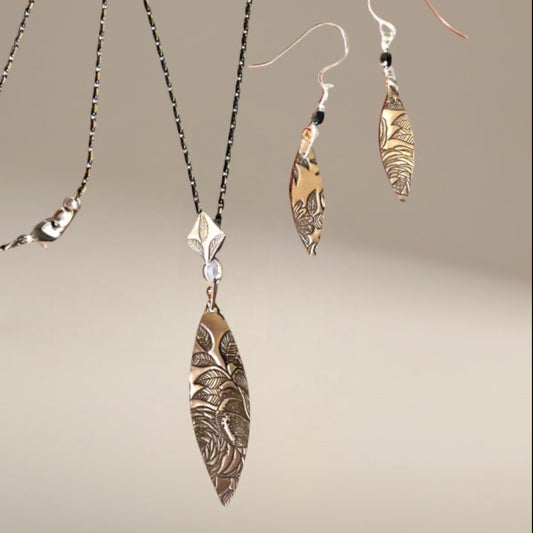 Bedrock Rose bronze pendant and earrings set with floral texture. Elongated diamond drop pendant and oval earrings with rose pattern.
