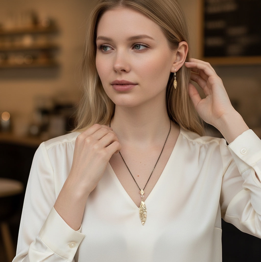 Bedrock Rose bronze pendant and earrings set with floral texture. Elongated diamond drop pendant and oval earrings with rose pattern.