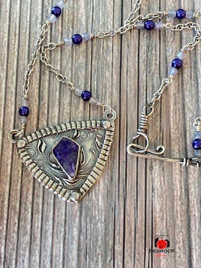 Bedrock Rose purple charoite gemstone pendant with silver floral motif and beaded chain with hook and eye clasp.