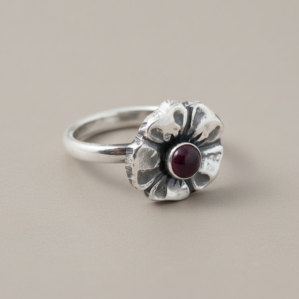 Bedrock Rose sterling silver ring with a garnet gemstone set in a cherry blossom design. Size 6.25.