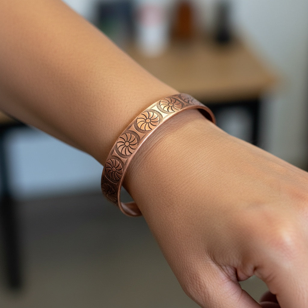 Bedrock Rose copper cuff bracelet with intricate pinwheel pattern and antiqued finish.