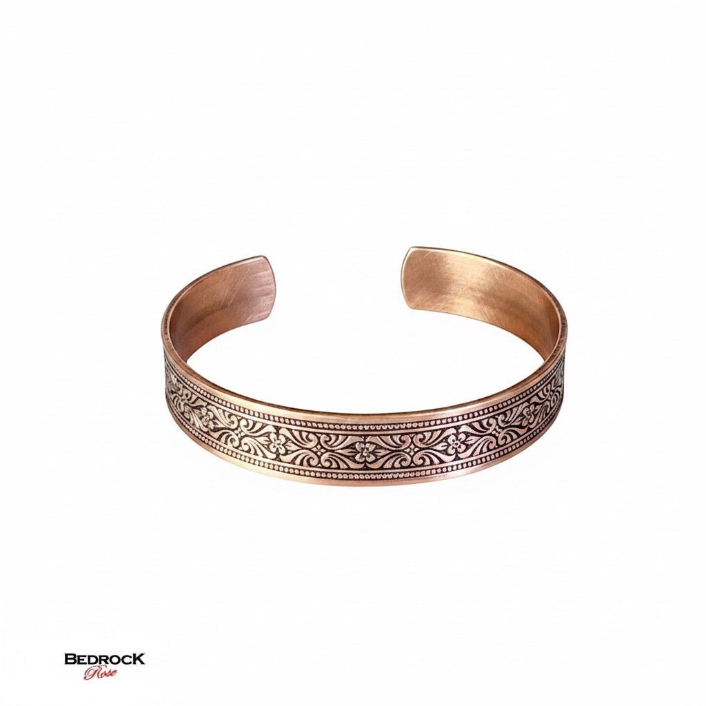 Bedrock Rose copper cuff bracelet with intricate scrollwork and floral details, polished finish.