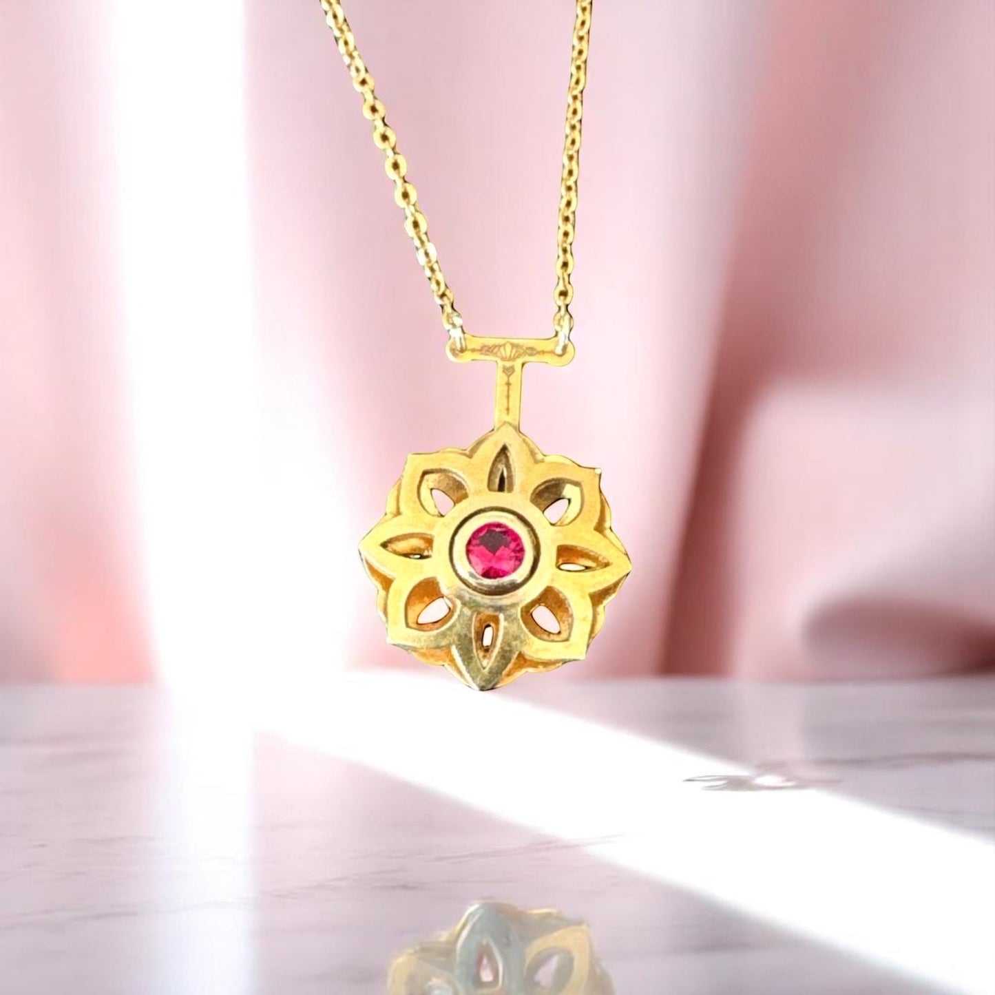 Bedrock Rose gold Art Deco floral pendant necklace with a central ruby gemstone.