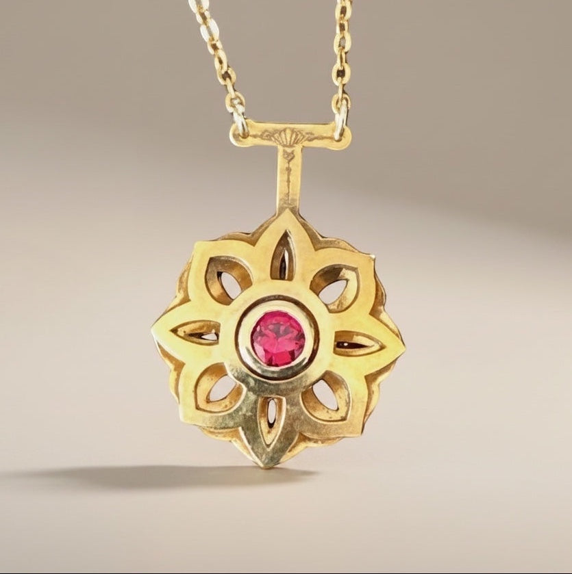 Bedrock Rose gold Art Deco floral pendant necklace with a central ruby. Intricate openwork design.